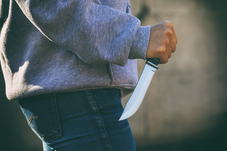 Concept on theme of attack: man in street with knife in his hands, close-upの写真素材