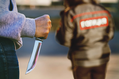 Man in the street with a knife in his hands. The concept of an attack on police officersの写真素材