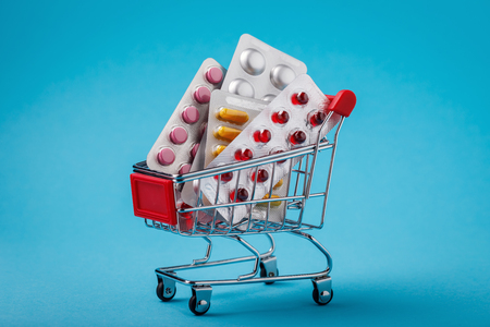 Trolley full of various pills on blue backgroundの写真素材
