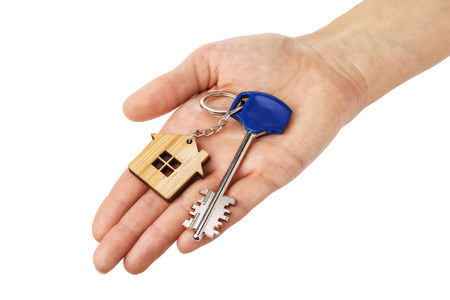 Keys to the apartment in hand isolated on white backgroundの写真素材