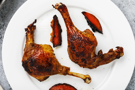 Baked duck with grilled oranges in a white plate close-up, top viewの写真素材
