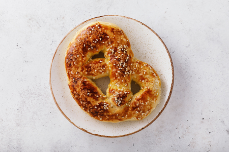 One fresh pretzel to beer in a ceramic plate on a tableの写真素材