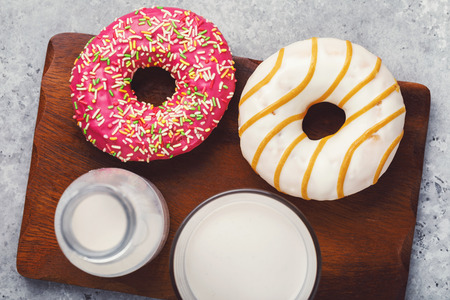 Strawberry and caramel donuts on a wooden support with a cedar milk, top viewの写真素材