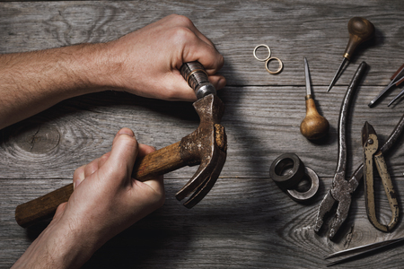 Workflow of increasing the gold ring in the jewelry workshop on the background of toolsの写真素材