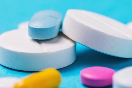 Various pills on a blue background, close-up