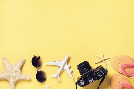 Beach accessories on a yellow background with copy space, top view. Vacation concept