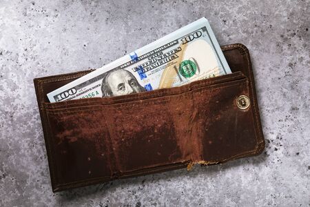 A pack of dollars in a wallet on the table, top view. Concept on the topic of storing money at home or in a bankの写真素材