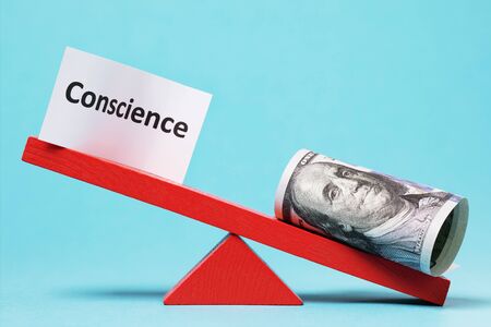 Paper sheet and money on a swing. The concept of conscienceの写真素材