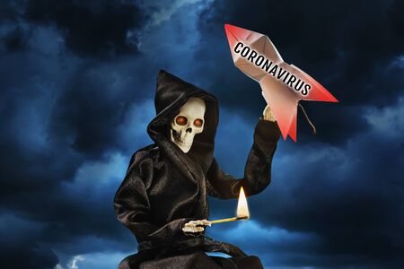 The skeleton holds a burning match in one hand and a bomb with a coronavirus in the other. The...