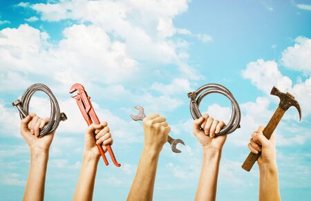 Plumbing tools in hands on sky background with copy space. Home master conceptの写真素材