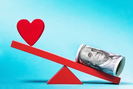 Heart and money on a swing. Concept on how much love costsの写真素材