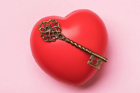The concept on the theme of the key to the heart on a pink background, top view