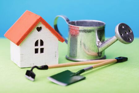 Toy house and garden tools on the table, close-upの写真素材