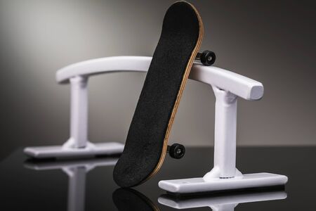 White metal railing and fingerboard on a dark background, close-upの写真素材