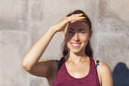 Young beautiful girl is engaged in morning exercises in the summer sunny morning in the fresh air. Healthy lifestyle conceptの写真素材