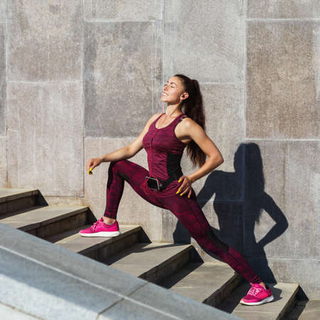 Young beautiful girl is engaged in morning exercises in the summer sunny morning in the fresh air....
