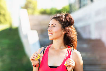 Young positive blonde size plus performs exercises with dumbbells in the park. The concept of a...