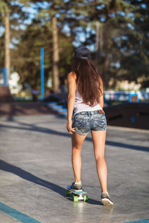 Girl riding a skateboard on a summer sunny evening