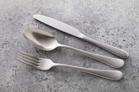 Cutlery on the table with concrete texture, close-up