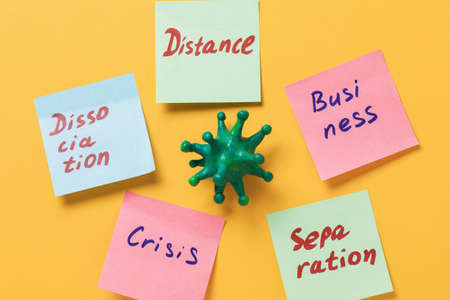 Toy bacteria and stickers with text on yellow background. Concept on the impact of coronavirus on...