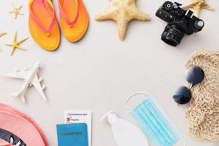 Flat composition with beach holiday accessories on light background and copy space in the center, summer background.の写真素材
