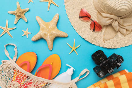 Flat composition with different accessories for a beach holiday on a blue background, summer background.の写真素材