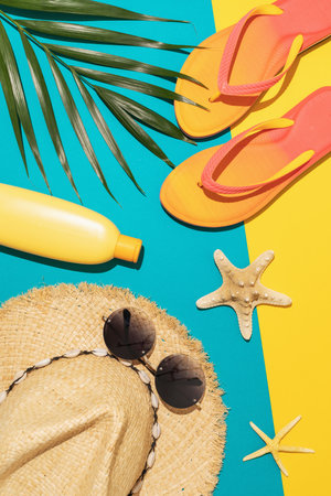 Flat composition with beach holiday accessories and palm leaf on colored background, summer background.の写真素材