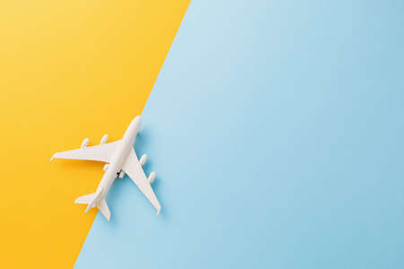 Toy white plane on a colored background, top view.の写真素材