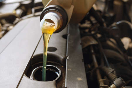 The process of pouring engine oil into the engine close-upの写真素材
