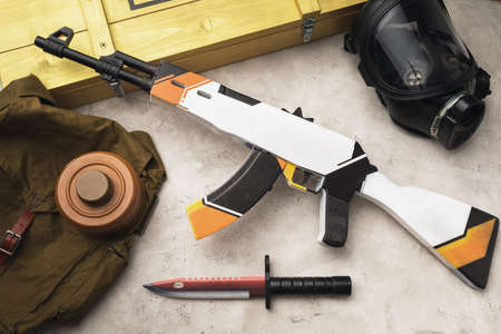 Wooden toy machine gun and bayonet knife on the table, top view