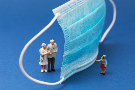 Medical mask and people on a blue background, concept on the topic of social distance, plastic toy menの写真素材