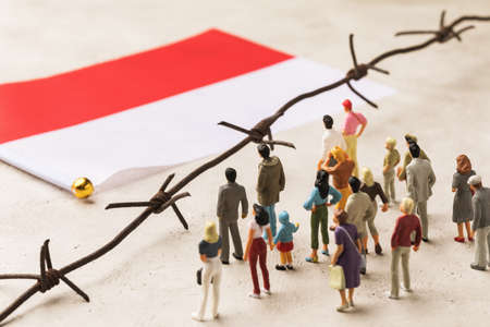 Poland flag, barbed wire and plastic toy men, the concept of migrants crossing the country borderの写真素材