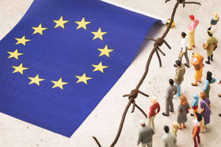Plastic toy men, barbed wire and eu flag, migrants crossing the border conceptの写真素材