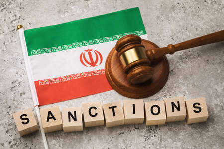 Iranian flag, judge's gavel and wooden cubes with text, concept on the topic of sanctions in Iranの写真素材