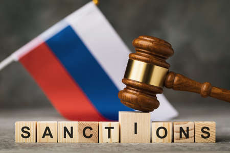 judge's gavel, wooden cubes with the text on the background of the Russian flag, the concept on the topic of sanctions in Russiaの写真素材