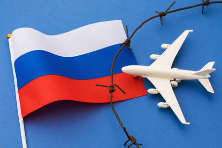 Toy plane, Russian flag and barbed wire on blue background, Russia air border violation conceptの写真素材
