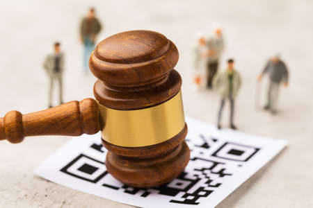 Judge gavel, barcode sheet and plastic toy men on abstract background, concept of administrative punishment for violation of the regime with QR codeの写真素材