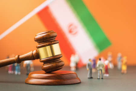 Judge gavel, flag and plastic toy men on colored background, Iran lawsuit conceptの写真素材