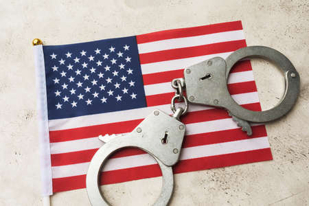 USA flag and handcuffs on an abstract background, the concept of crime in the American societyの写真素材