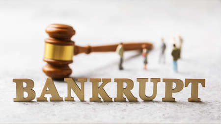 Lettering from wooden letters, judge gavel and plastic toy men, bankruptcy conceptの写真素材