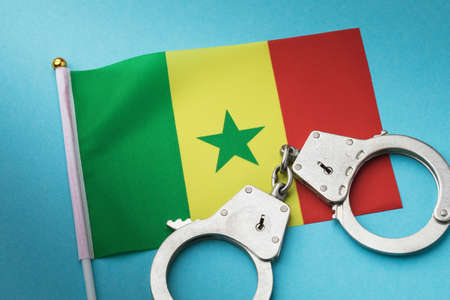 Senegal flag and handcuffs on a blue background, concept on the theme of crime in the country, top viewの写真素材