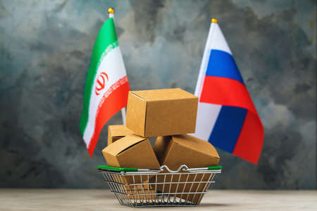 Various boxes in a food basket and two flags on an abstract background, the concept of trade between Iran and Russiaの写真素材