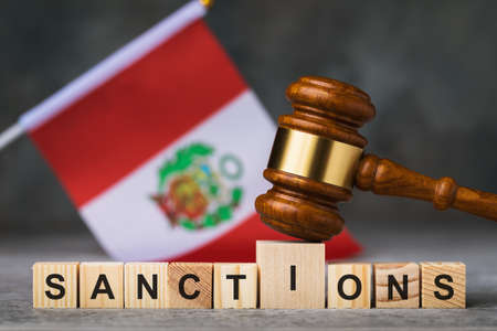 Judge gavel, wooden cubes with text on the background of the Peruvian flag, concept on the theme of sanctions in Peruの写真素材