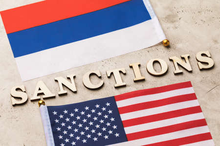 Text from wooden letters and two flags, the concept of sanctions against Russia from Americaの写真素材