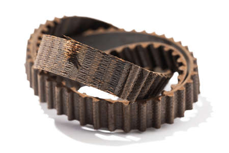 Old torn car timing belt isolated on white background
