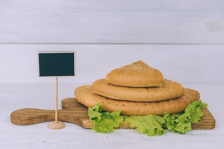Tortilla bread with greens sliced on a cutting board on a white tableの写真素材