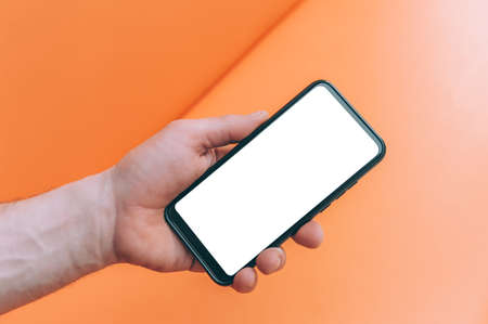 Mock-up technology. Man holds a smartphone in his hands close-upの写真素材