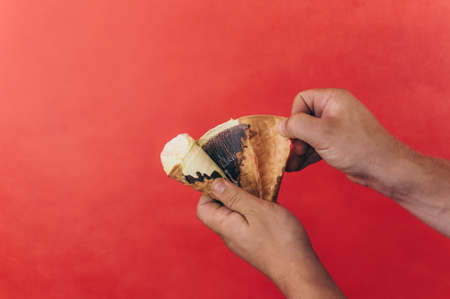 Man holds an ice cream in his hand on a red background