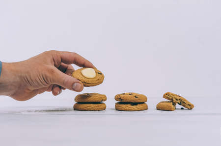 The guy holds oatmeal cookies in his hand on a light background