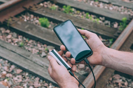The guy charges a smartphone through a portable charger